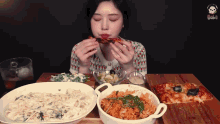 a woman is sitting at a table eating pizza