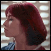 a close up of a woman 's face with short red hair