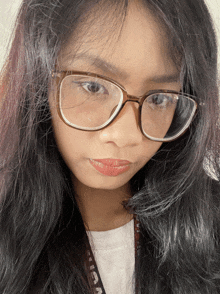 a girl wearing glasses has a lanyard around her neck that says icaa