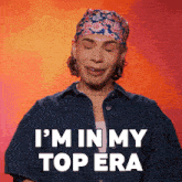 a man wearing a headband and a denim shirt says i 'm in my top era