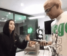 a man and woman are standing next to each other in a room .