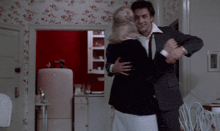 a man in a suit is dancing with a woman