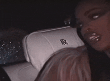 a woman is sitting in the back seat of a white rolls royce .