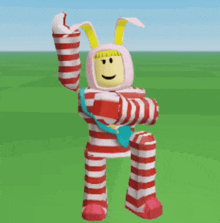a cartoon character in a red and white striped outfit with bunny ears is standing in a grassy field .