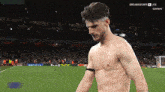 a shirtless man stands on a soccer field in front of a crowd with the words premier sports live on the bottom