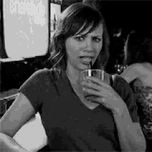 a woman is drinking through a straw from a glass .