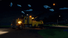 a yellow tow truck is parked in the dark