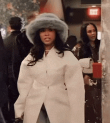 a woman is wearing a fur hat and a white coat .