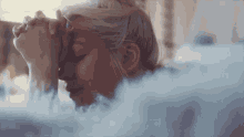 a woman with her eyes closed is surrounded by a cloud of smoke