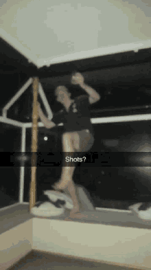 a blurry photo of a person holding a glass with the caption shots