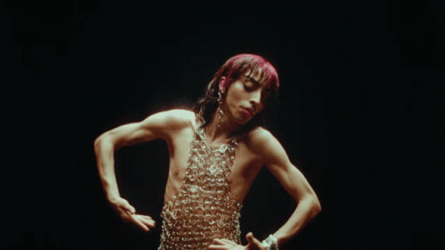 a man without a shirt is wearing chains around his neck and chest