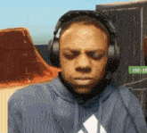 a man wearing headphones and a hoodie with an adidas logo
