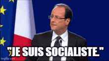 a man in a suit and tie is giving a speech in front of a flag and says " je suis socialiste "