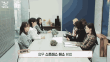 a group of women sitting around a table with a sign that says twice on it