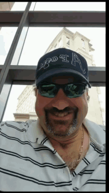 a man wearing sunglasses and a hat that says a on it