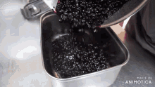 a person pouring black beans into a metal container made in animotica