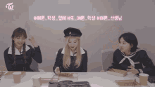 a group of girls are sitting at a table and one of them is wearing a sailor suit