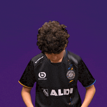 a man wearing a black shirt with aldi on it