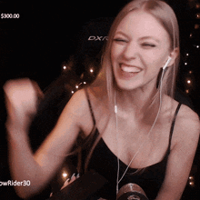 a woman wearing headphones and a black tank top with a dxr logo on the back of her chair