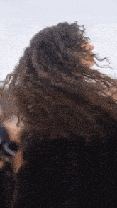a woman with curly hair is wearing a black shirt