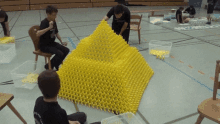 a man wearing a black shirt that says ' ucsd ' on it is working on a pyramid