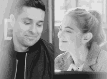 a black and white photo of a man and woman smiling