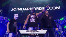 a dark order wrestler is standing in front of a banner that says joindarkorder.com
