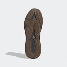 a close up of the bottom of a brown adidas shoe
