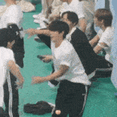 a group of young men are sitting on the floor and dancing .