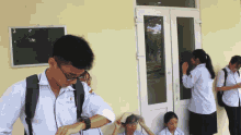a boy wearing a shirt with the letter f on it looks at his watch