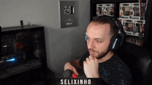 a man wearing headphones has the name selixinho on the bottom of his shirt