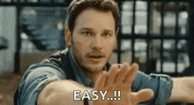 a man is holding his hands out in front of his face and saying `` easy ! ''