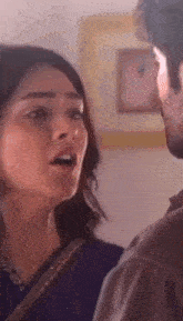 a man and a woman are standing next to each other in a room .