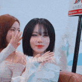 two girls are sitting next to each other and one of them has the word myangky on her shirt