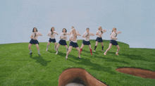 a group of girls are standing on top of a giant clover