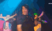 a man in a black shirt is dancing in front of a crowd in a club ..