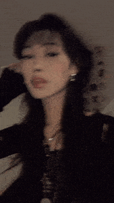 a woman wearing a black shirt and a necklace has a dog tag on her neck