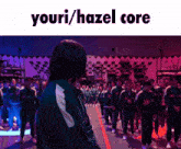 a man stands in front of a crowd with the words youri / hazel core written above him