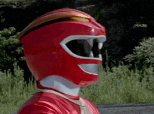 a close up of a red power ranger 's helmet with his mouth open .
