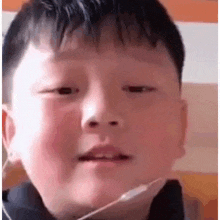 a young boy is making a funny face with his mouth open .