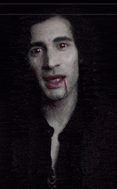 a man with red eyes and a bloody mouth looks like a vampire
