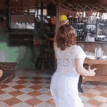 a woman in a white dress is dancing in front of a bar .