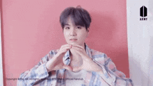 a man is making a heart shape with his hands .