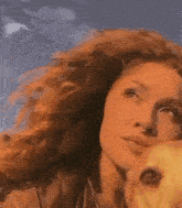 a woman with red hair and a nose ring is holding a dog .