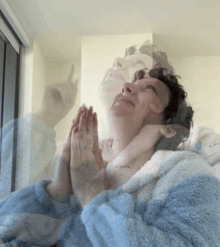 a person with their hands folded in front of a window with a reflection of another person