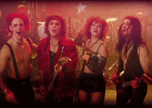 a group of people are singing and playing guitars in a band