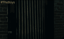 a man in a hoodie is peeking out of a door with #theboys written on the bottom