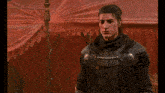 a man in a video game is standing in front of a red tent