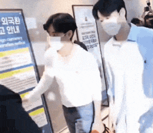 two men wearing face masks are standing in front of a sign that says foreign currency exchange notice