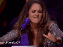 a woman is making a funny face in front of a microphone with the hashtag lialmeida05
